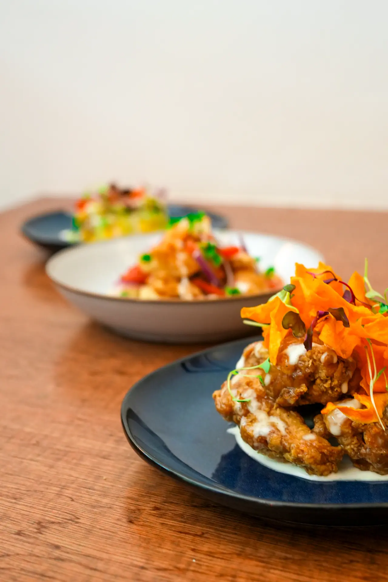 Three Maka dishes lined up along a wooden table